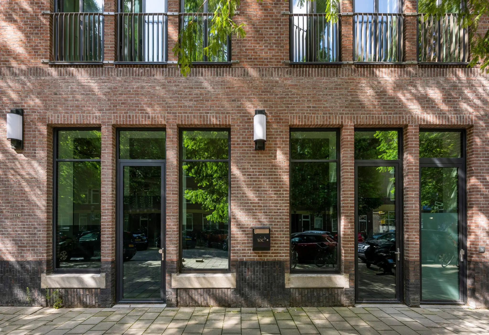 Voorgevel van een modern bakstenen appartementencomplex aan de Karel du Jardinstraat met grote ramen en twee entreedeuren.